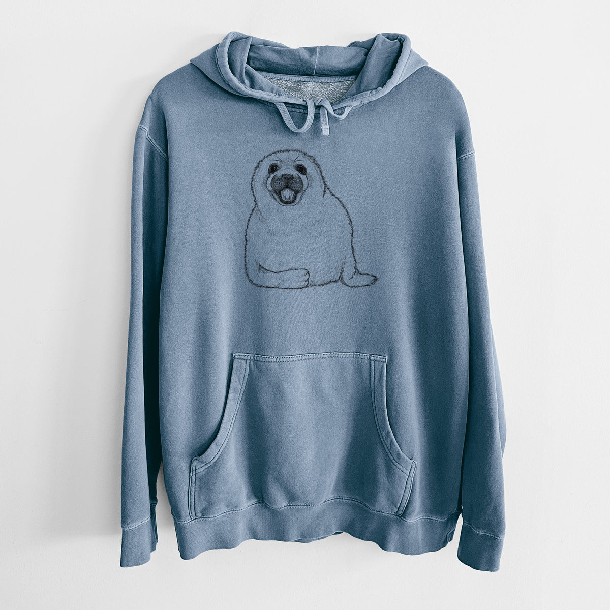 Slate blue pigment dyed hoodie laid flat, printed with a black ink illustration of a smiling harp seal pup lying down.