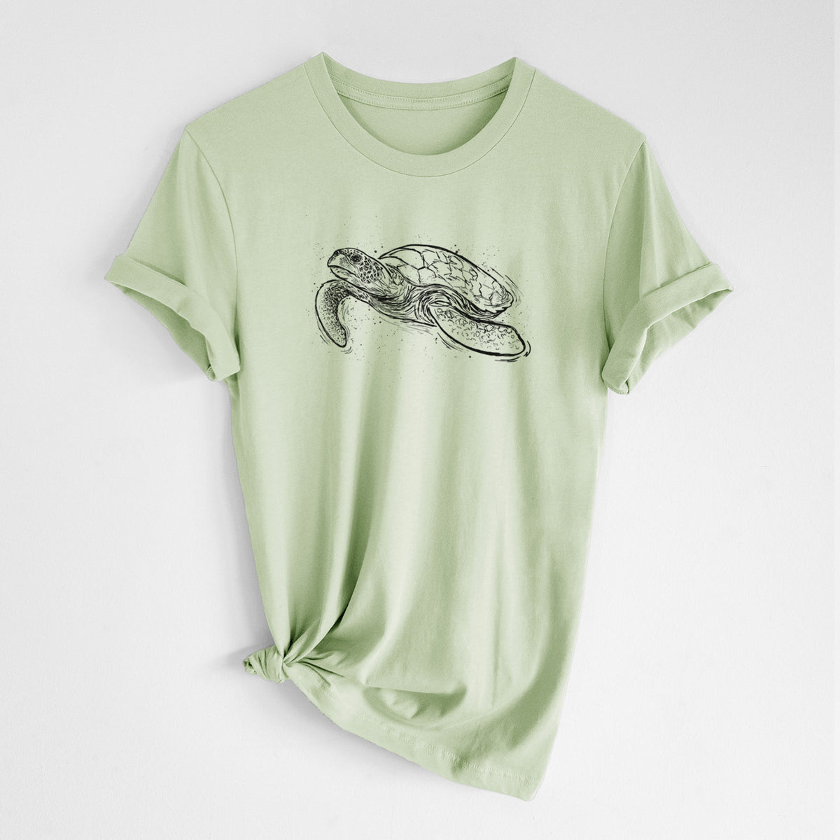Spring green lightweight cotton t-shirt laid flat with the sleeves rolled, printed with a black ink illustration of a hawksbill sea turtle swimming, with a patterned shell.