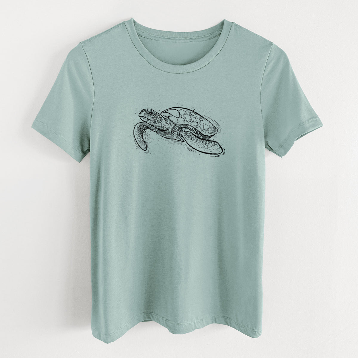 Dusty blue women's relaxed fit cotton t-shirt laid flat, printed with a black ink illustration of a hawksbill sea turtle swimming, with a patterned shell.