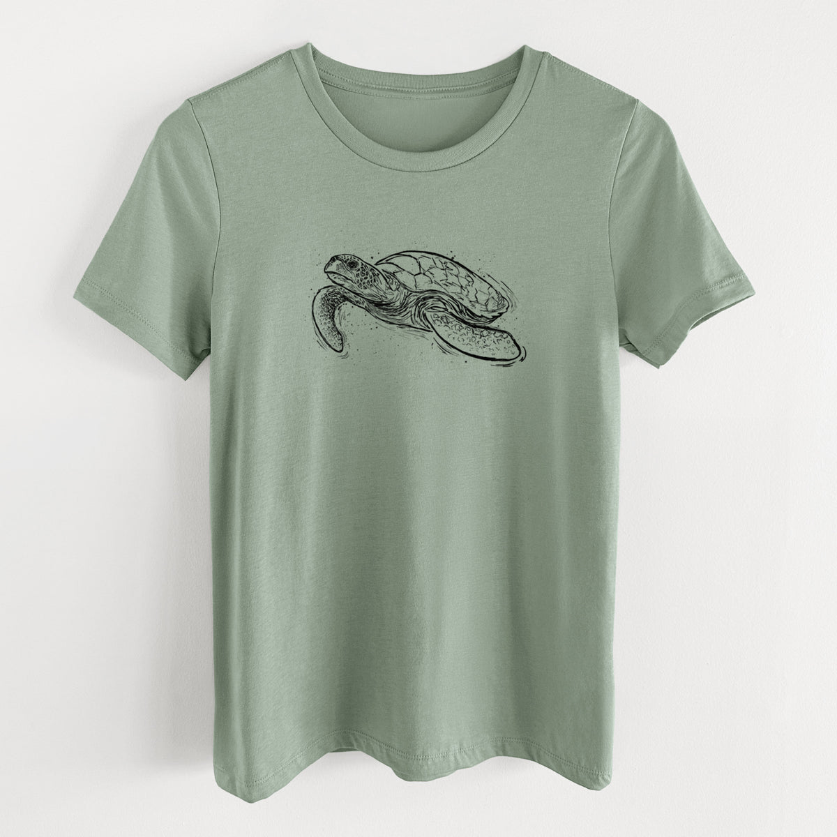 Sage green women's relaxed fit cotton t-shirt laid flat, printed with a black ink illustration of a hawksbill sea turtle swimming, with a patterned shell.