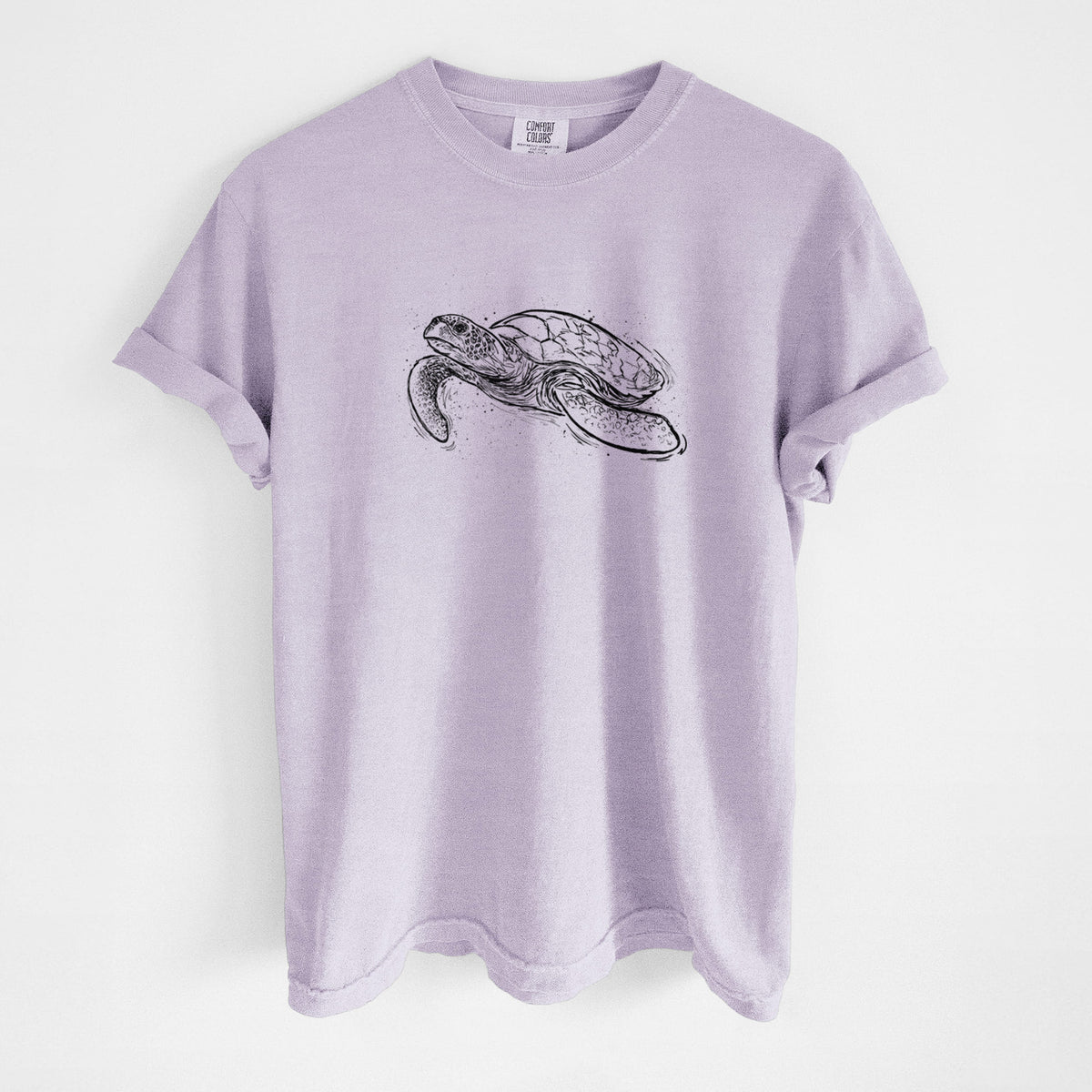 Orchid purple Comfort Colors t-shirt laid flat, printed with a black ink illustration of a hawksbill sea turtle swimming, with a patterned shell.