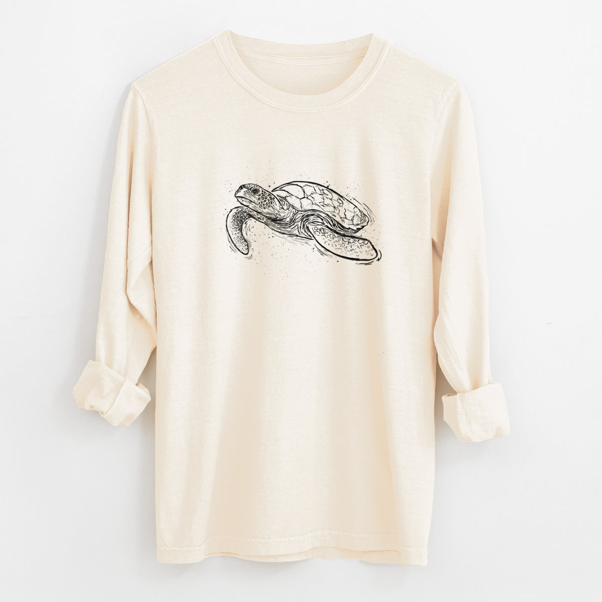 Ivory Comfort Colors long sleeve shirt laid flat with the cuffs rolled, printed with a black ink illustration of a hawksbill sea turtle swimming, with a patterned shell.