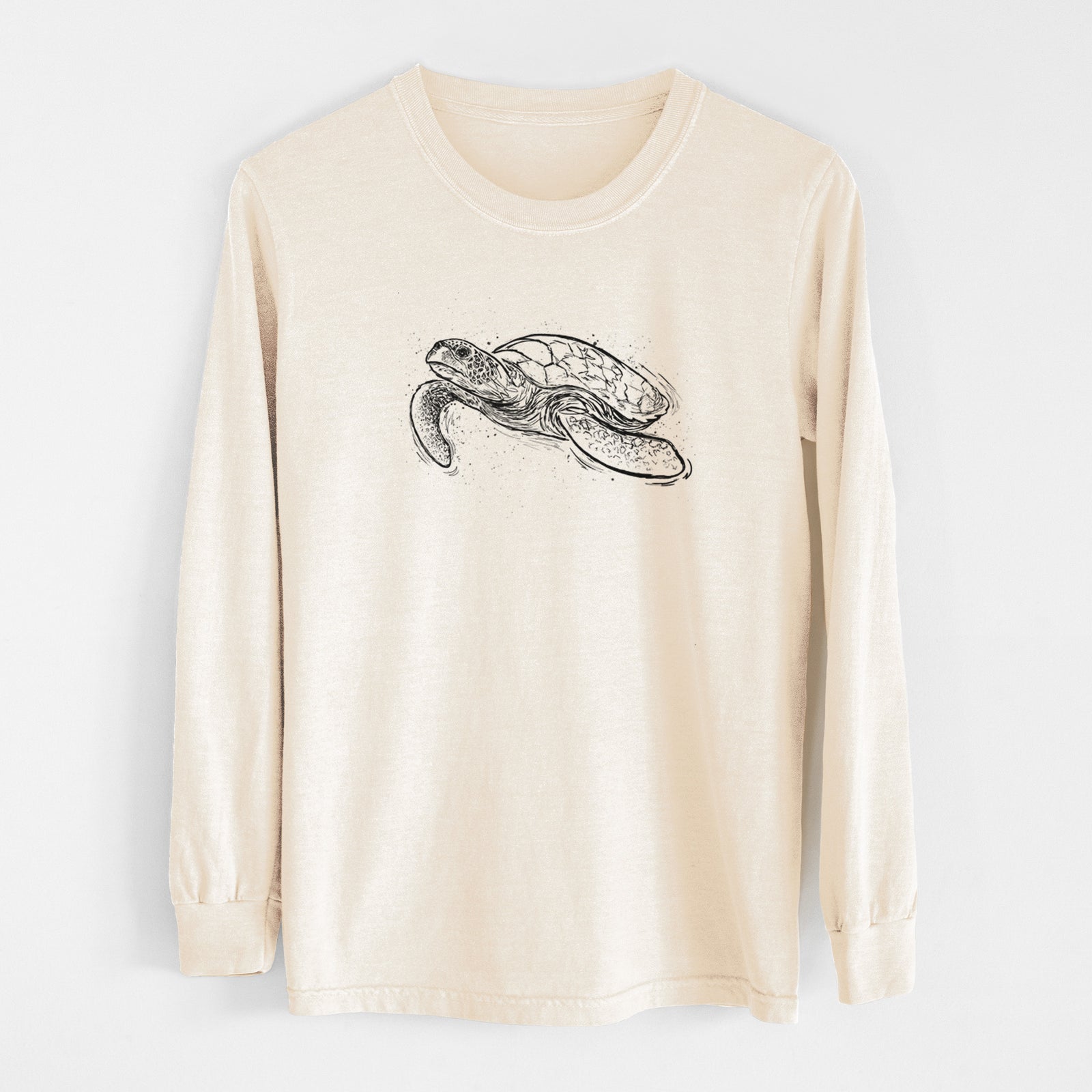 Ivory Comfort Colors long sleeve shirt laid flat, printed with a black ink illustration of a hawksbill sea turtle swimming, with a patterned shell.