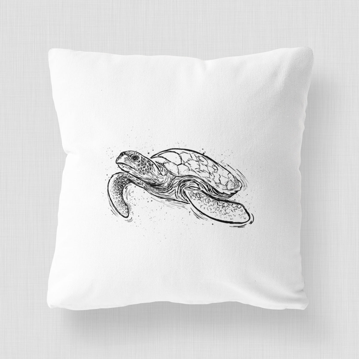 White pillow cover printed with a black ink illustration of a hawksbill sea turtle swimming, with a patterned shell.