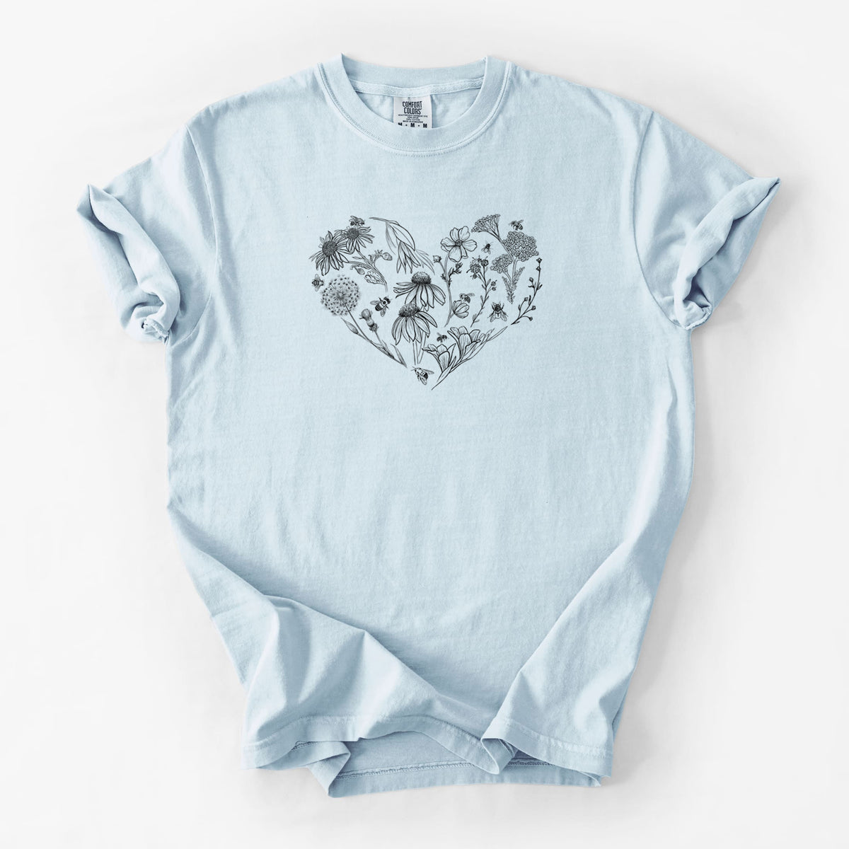 Chambray blue Comfort Colors t-shirt laid flat, printed with a heart shape filled with black ink flowers and bees.