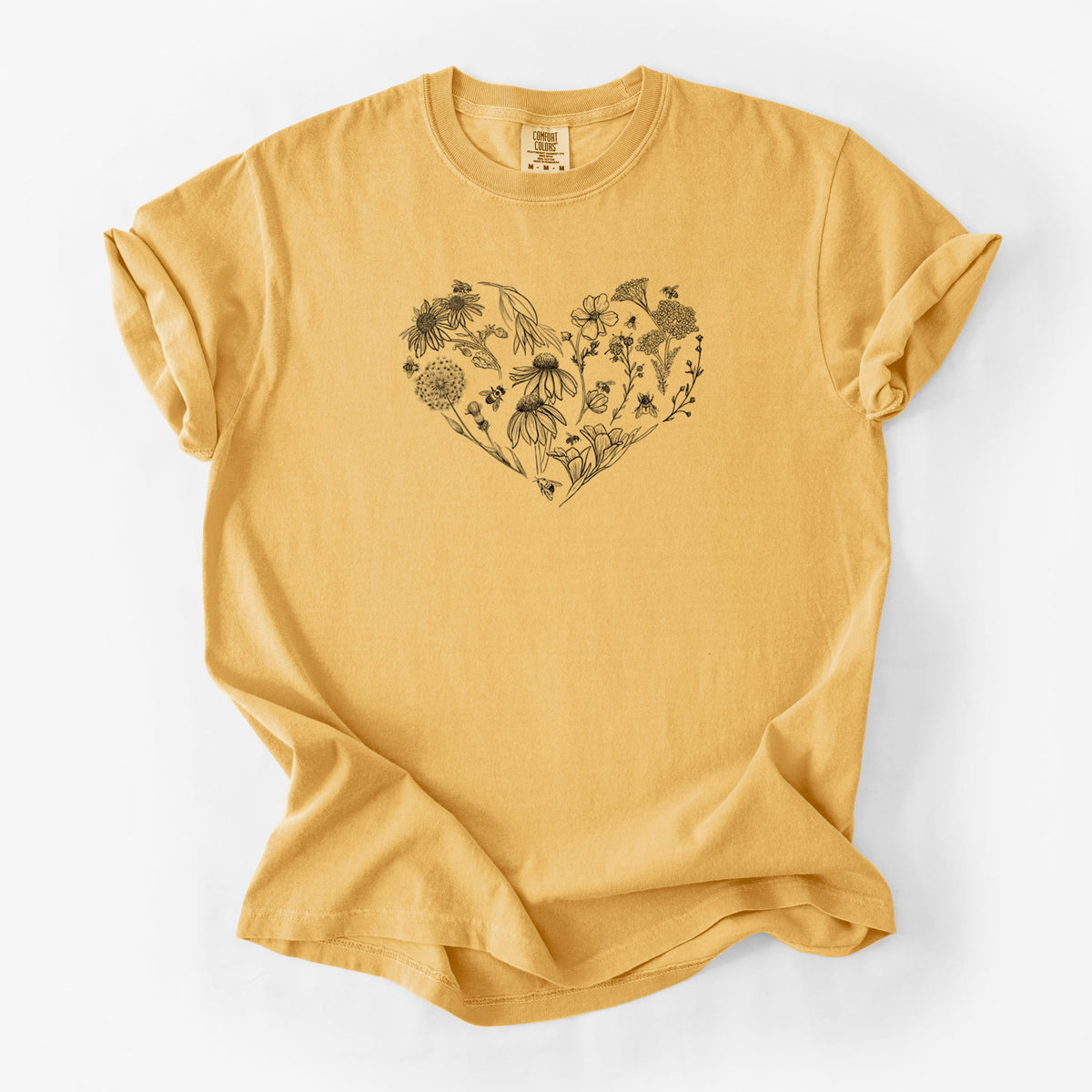 Golden wheat yellow Comfort Colors t-shirt laid flat, printed with a heart shape filled with black ink flowers and bees.