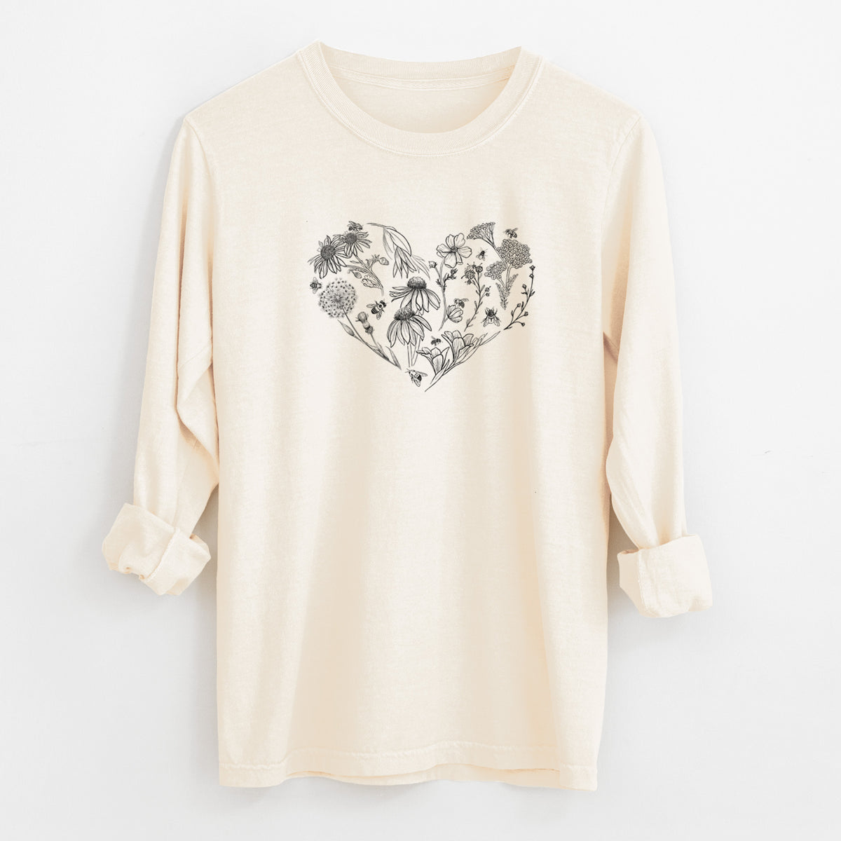 Ivory Comfort Colors long sleeve shirt laid flat with the cuffs rolled, printed with a heart shape filled with black ink flowers and bees.