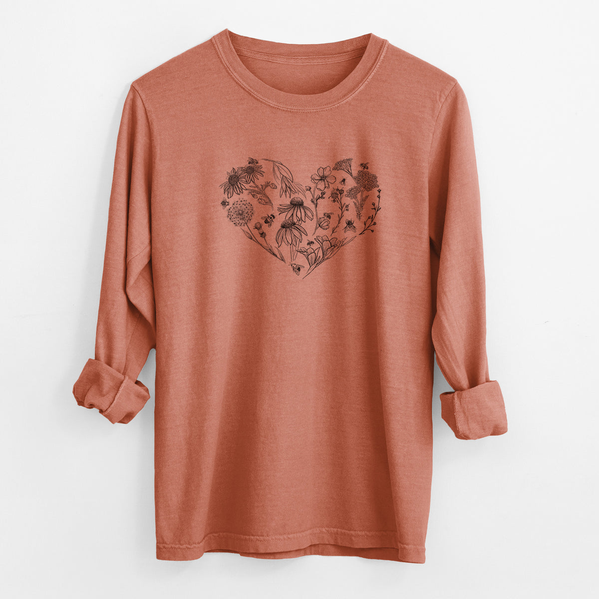 Yam burnt orange Comfort Colors long sleeve shirt laid flat with the cuffs rolled, printed with a heart shape filled with black ink flowers and bees.