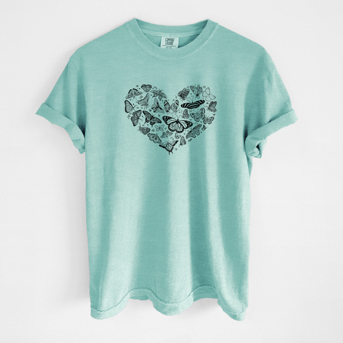 Chalky mint Comfort Colors t-shirt laid flat, printed with a heart shape filled with small black ink butterflies and moths.