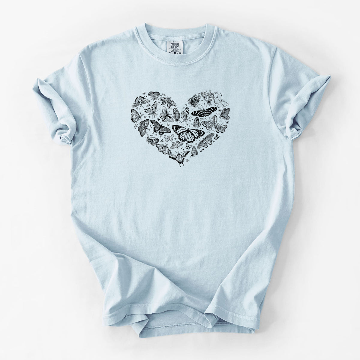 Chambray blue Comfort Colors t-shirt laid flat, printed with a heart shape filled with small black ink butterflies and moths.