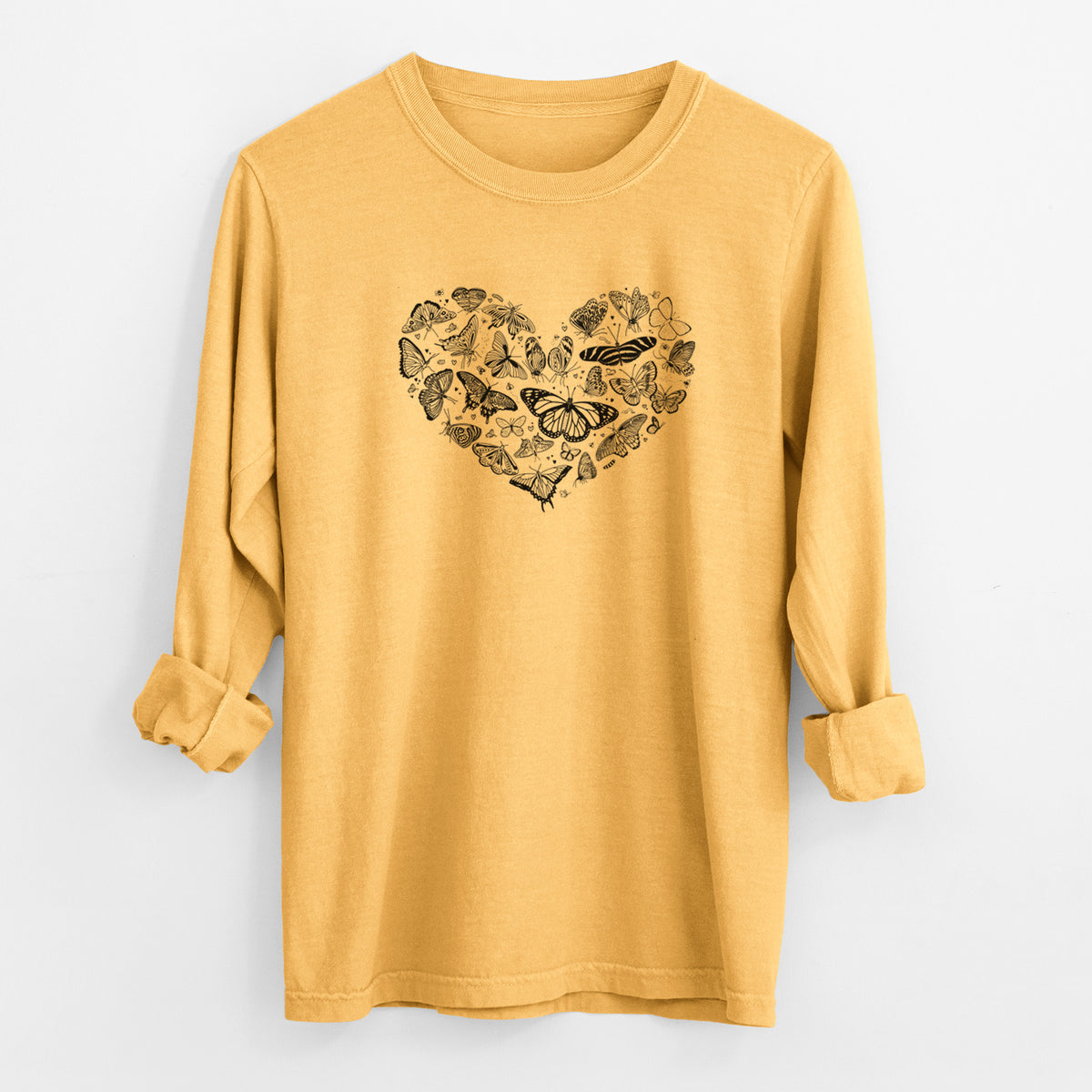 Golden wheat yellow Comfort Colors long sleeve shirt laid flat with the cuffs rolled, printed with a heart shape filled with small black ink butterflies and moths.