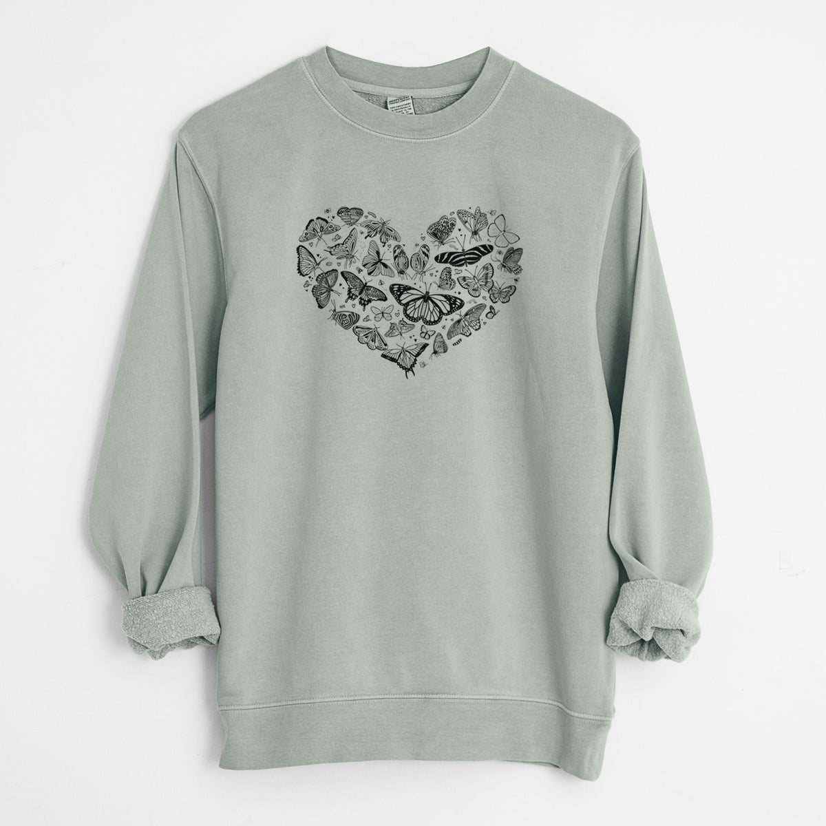 Sage green pigment dyed crewneck sweatshirt laid flat with the sleeves rolled, printed with a heart shape filled with small black ink butterflies and moths.