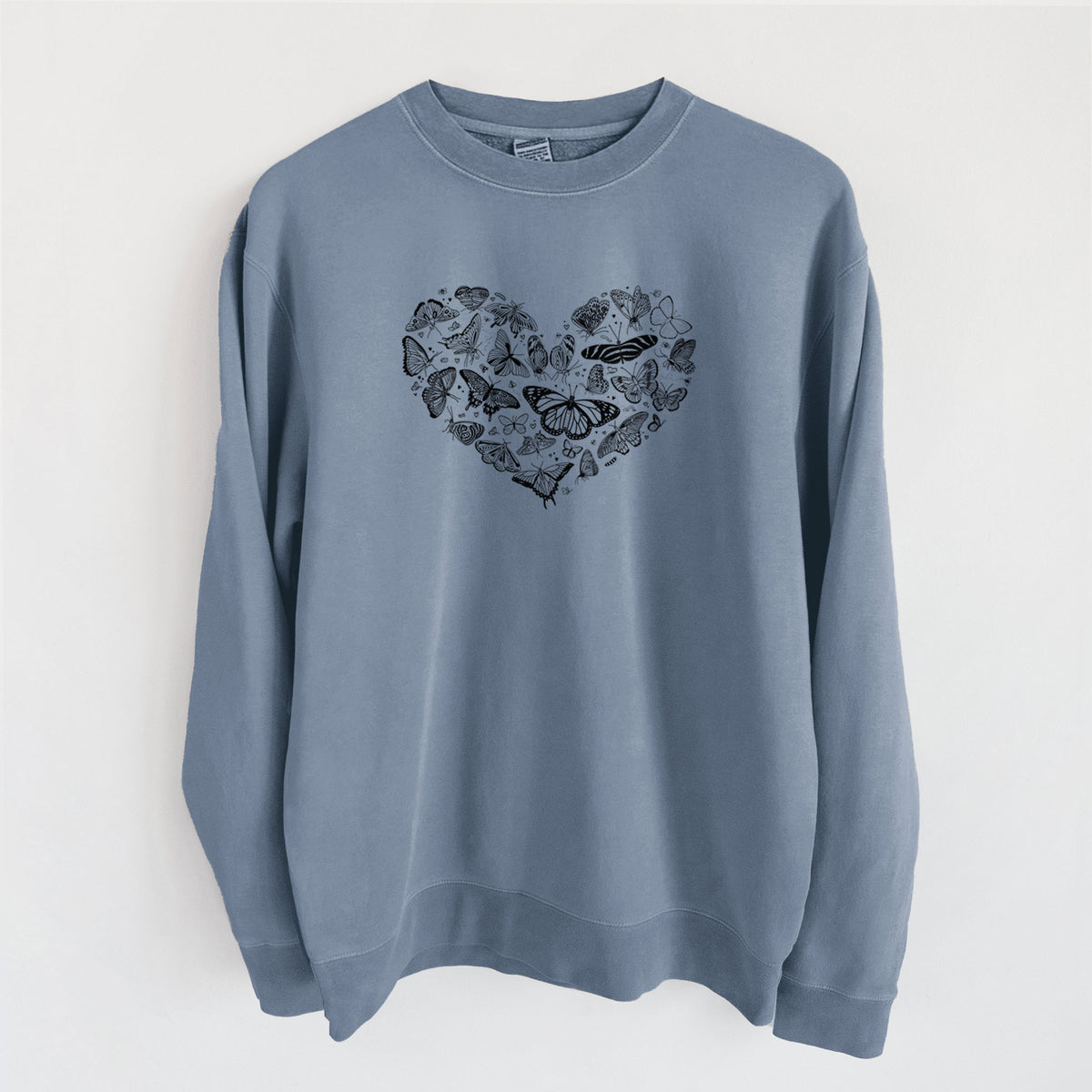 Slate blue pigment dyed crewneck sweatshirt laid flat, printed with a heart shape filled with small black ink butterflies and moths.