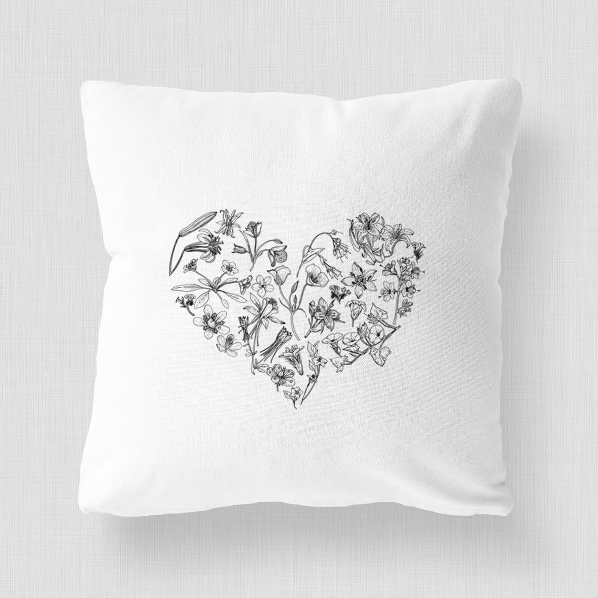 White pillow cover printed with a heart shape filled with black ink California mountain wildflowers.