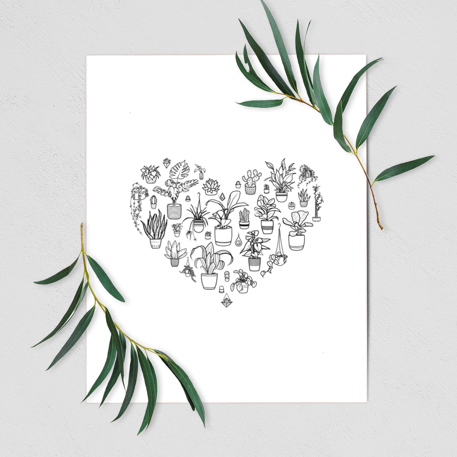 Art print of a heart shape filled with black ink potted houseplants, shown with eucalyptus leaves.