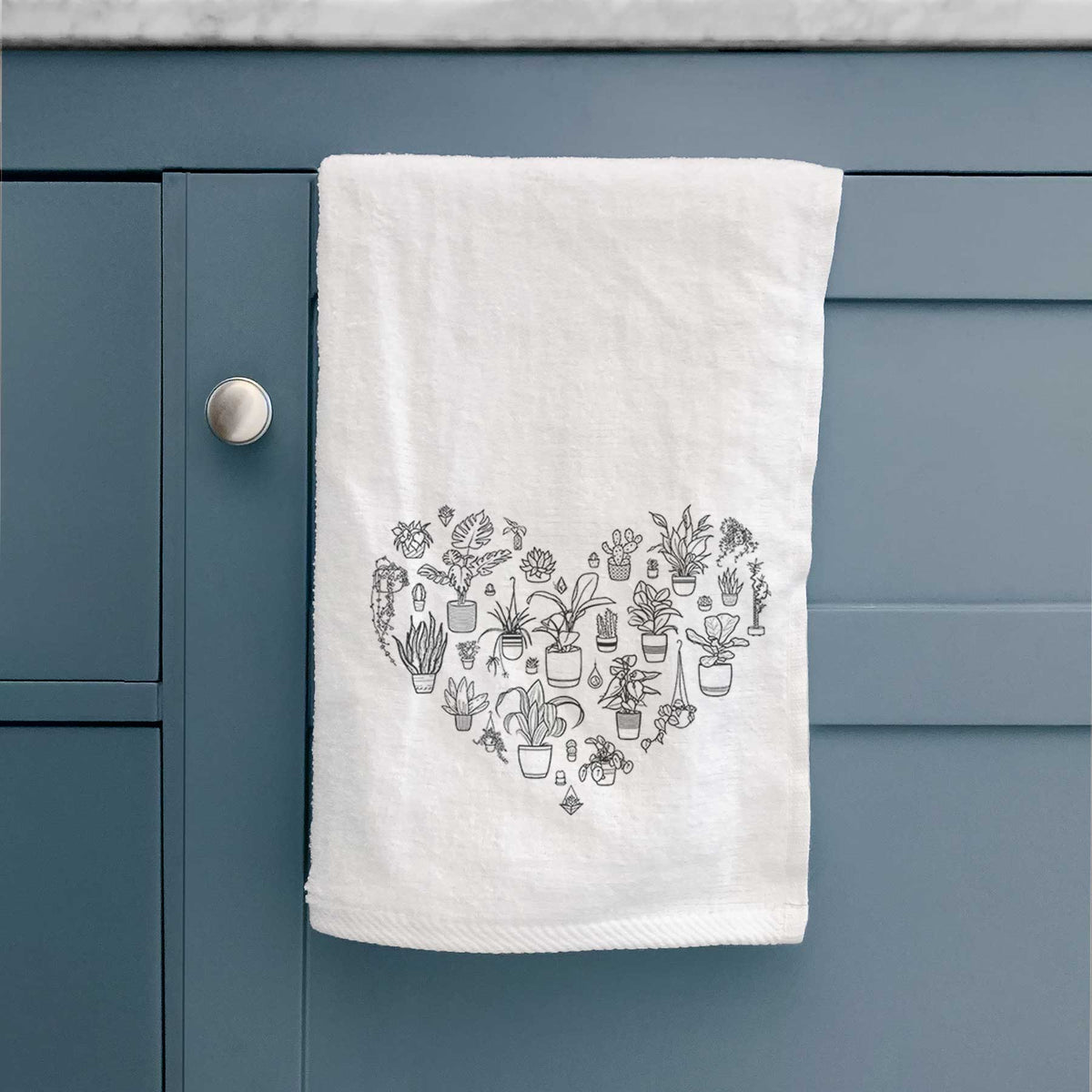 White hand towel printed with a heart shape filled with black ink potted houseplants.