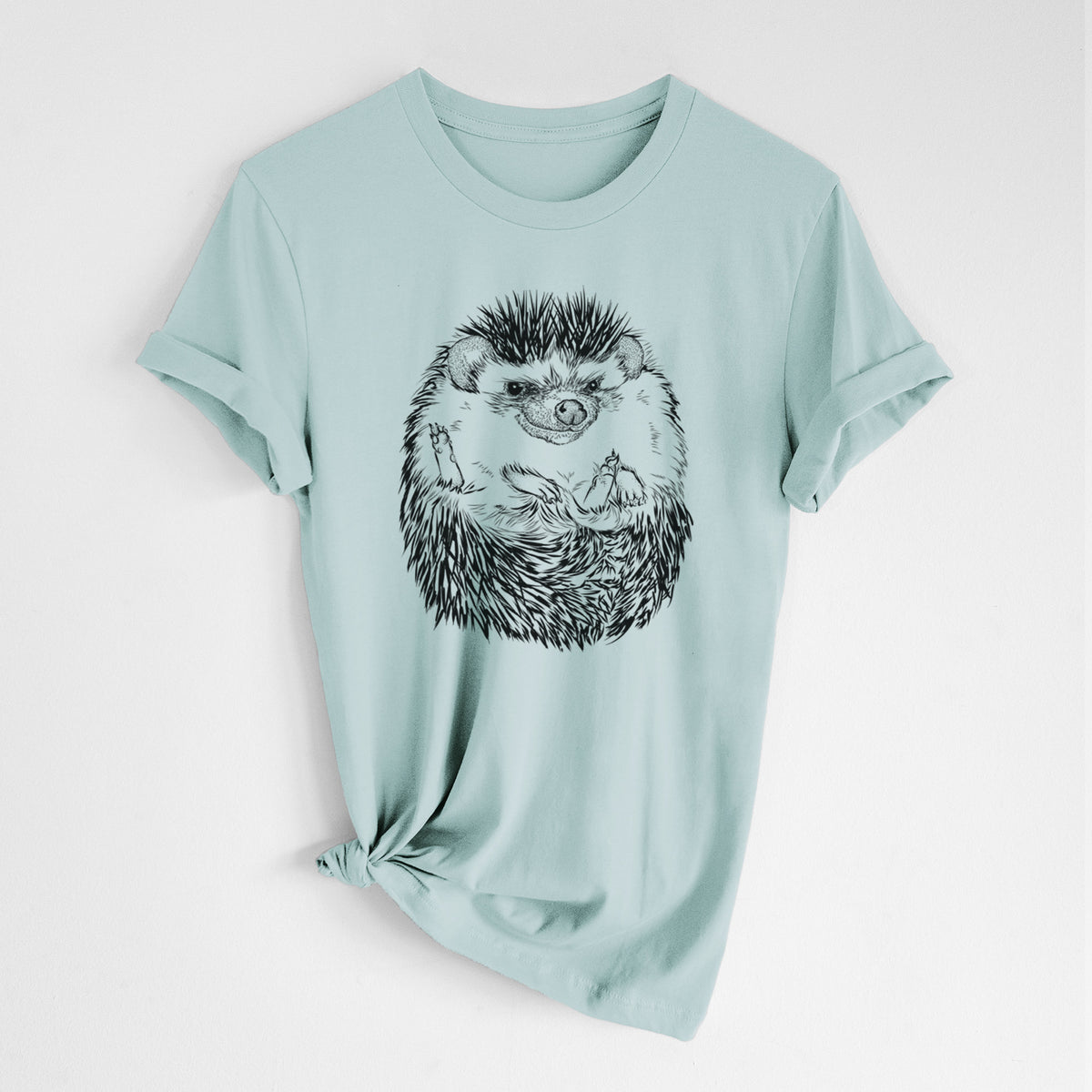 Dusty blue lightweight cotton t-shirt laid flat with the sleeves rolled, printed with a detailed black ink illustration of a hedgehog curled up and facing forward.
