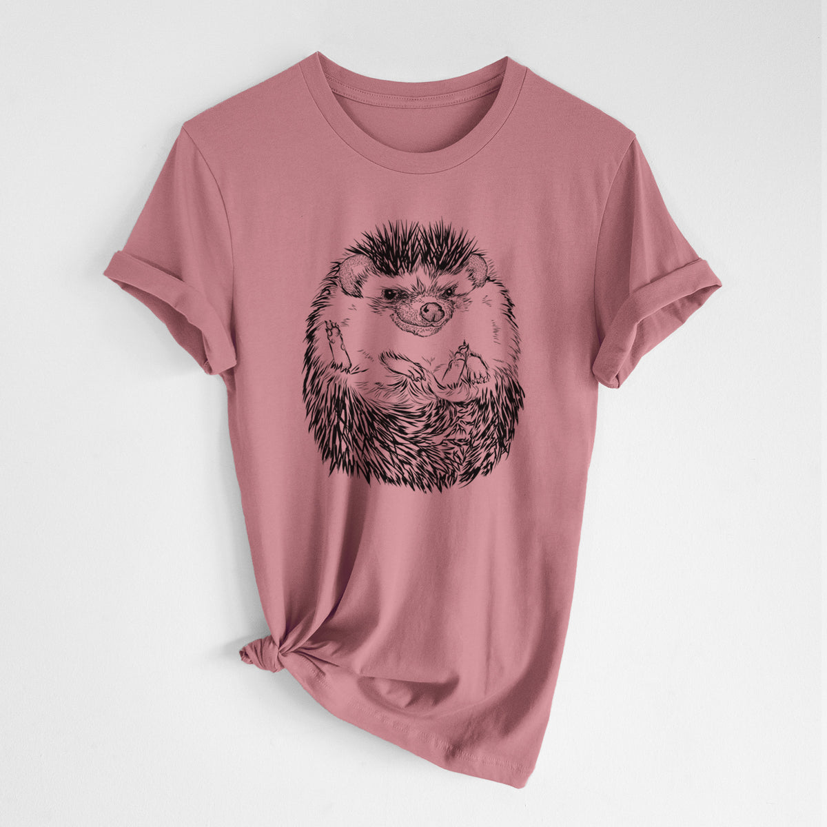 Mauve pink lightweight cotton t-shirt laid flat with the sleeves rolled, printed with a detailed black ink illustration of a hedgehog curled up and facing forward.