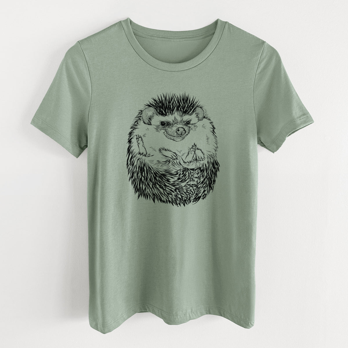 Sage green women's relaxed fit cotton t-shirt laid flat, printed with a detailed black ink illustration of a hedgehog curled up and facing forward.
