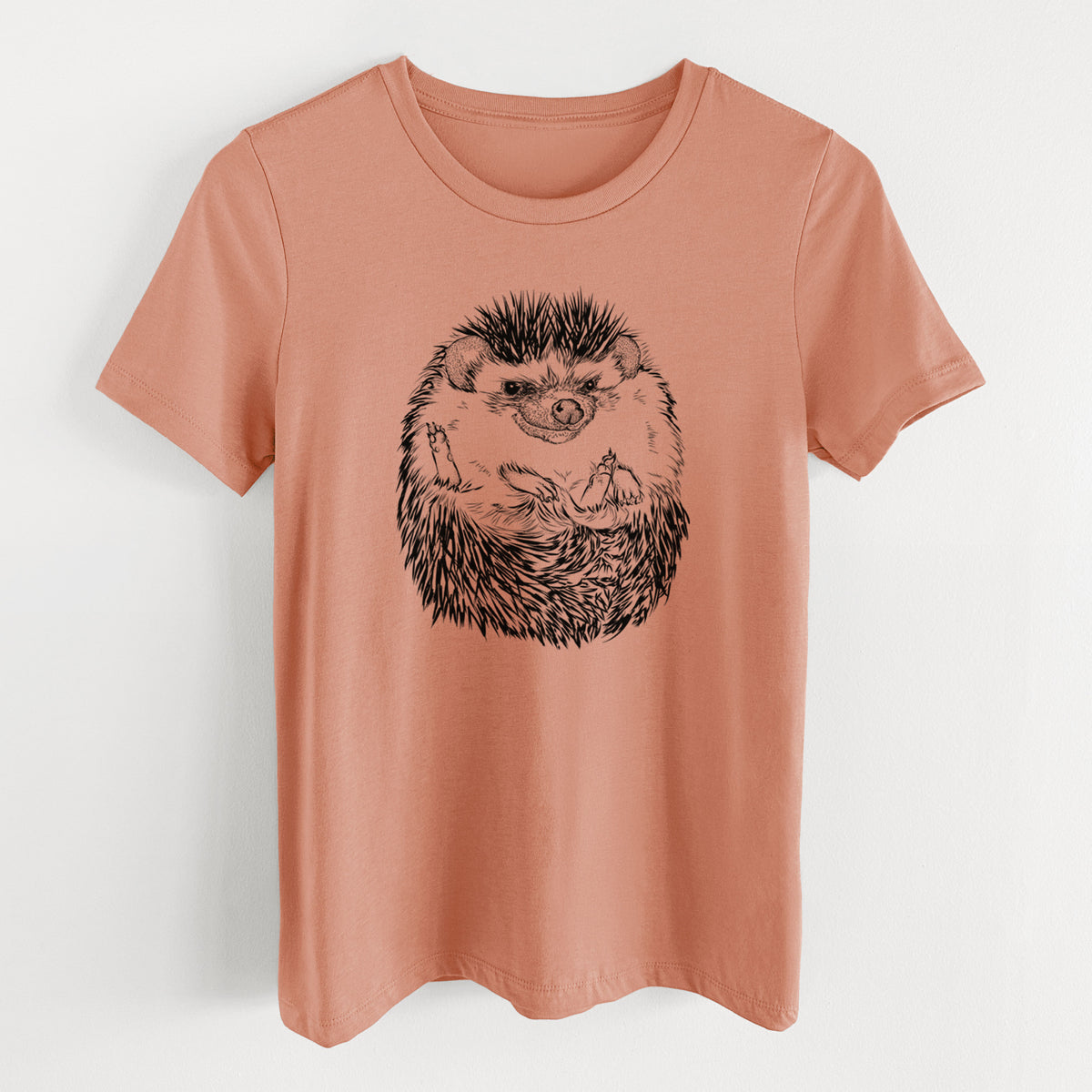 Terracotta orange women's relaxed fit cotton t-shirt laid flat, printed with a detailed black ink illustration of a hedgehog curled up and facing forward.