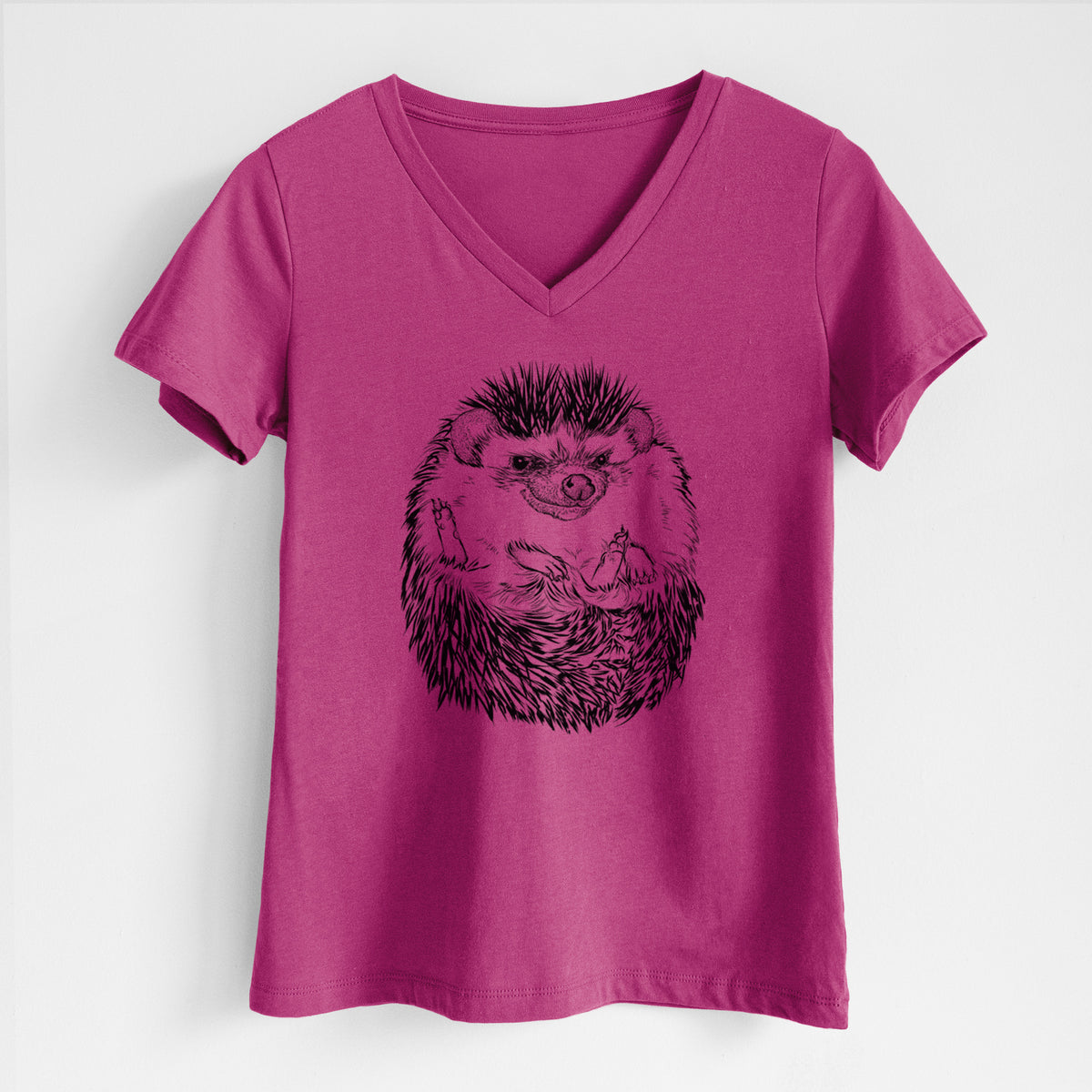 Berry pink women's relaxed fit cotton V-neck t-shirt laid flat, printed with a detailed black ink illustration of a hedgehog curled up and facing forward.