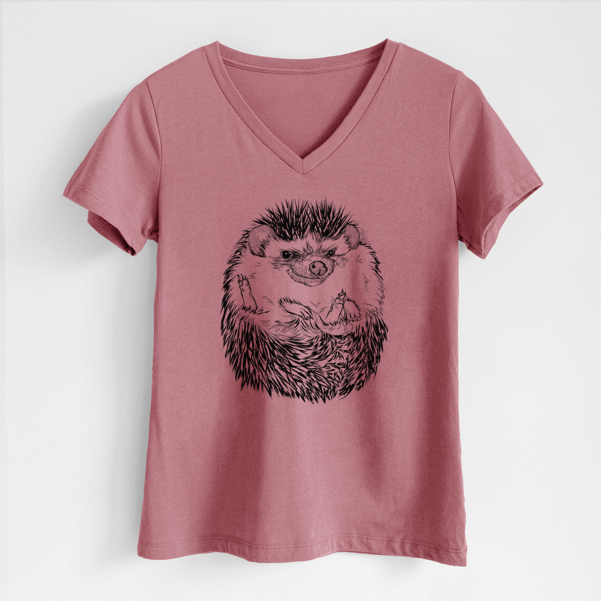 Mauve pink women's relaxed fit cotton V-neck t-shirt laid flat, printed with a detailed black ink illustration of a hedgehog curled up and facing forward.