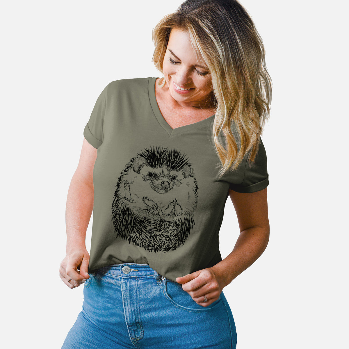 Woman wearing a military green women's relaxed fit cotton V-neck t-shirt printed with a detailed black ink illustration of a hedgehog curled up and facing forward.