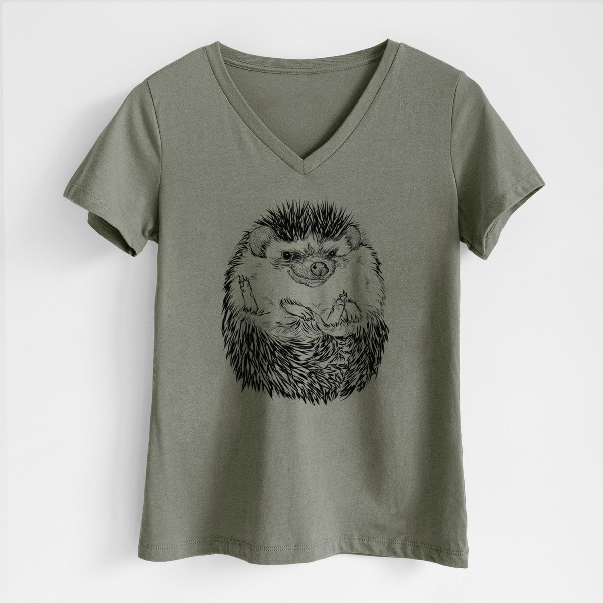 Military green women's relaxed fit cotton V-neck t-shirt laid flat, printed with a detailed black ink illustration of a hedgehog curled up and facing forward.