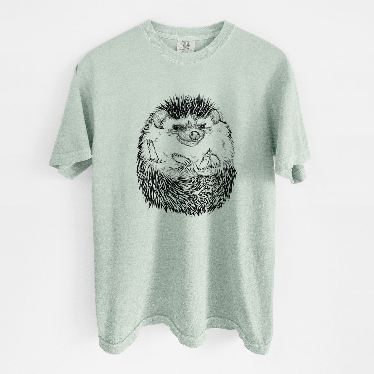 Bay green Comfort Colors t-shirt laid flat, printed with a detailed black ink illustration of a hedgehog curled up and facing forward.