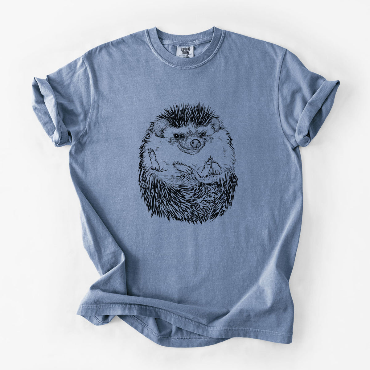 Blue jean Comfort Colors t-shirt laid flat, printed with a detailed black ink illustration of a hedgehog curled up and facing forward.