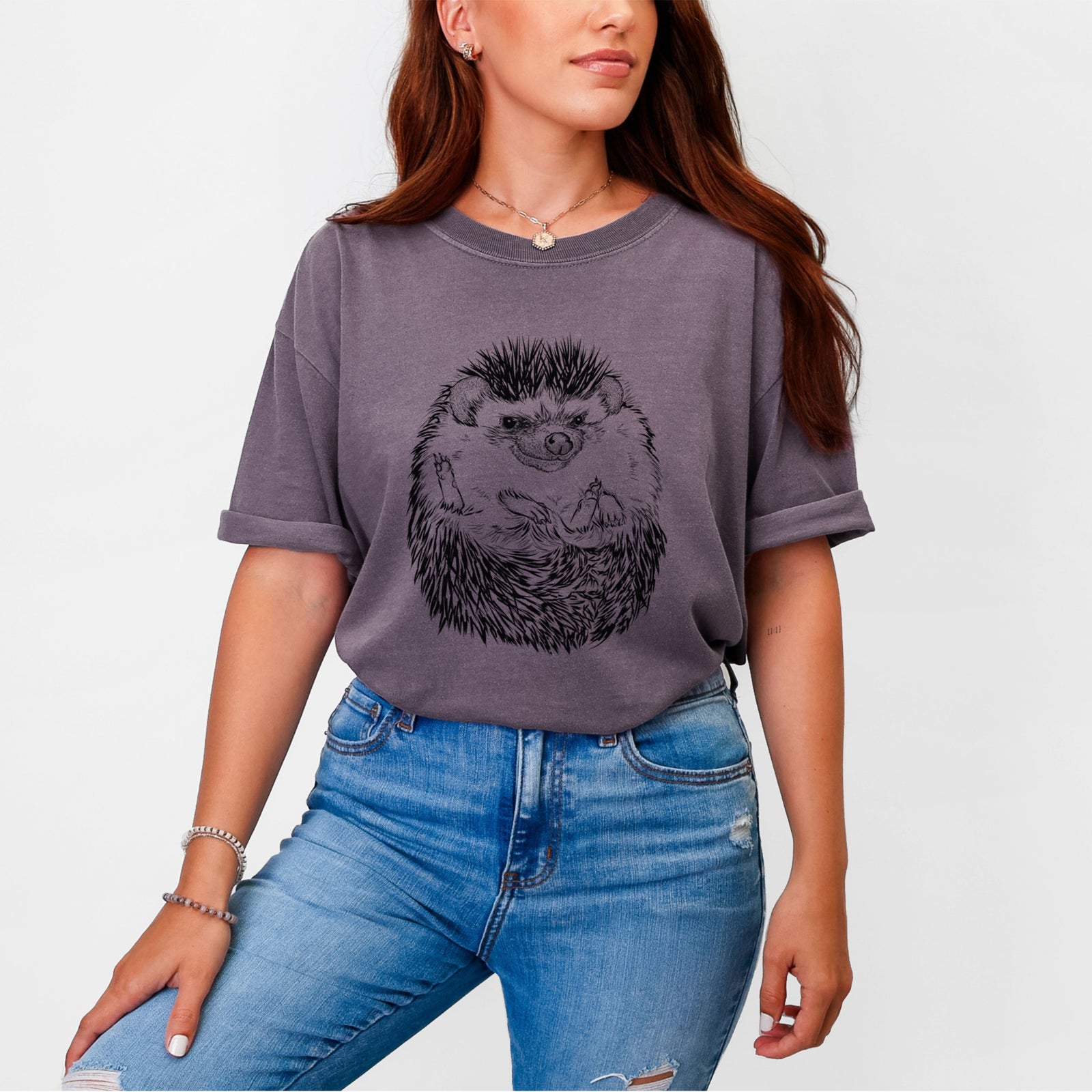 Blue jean Comfort Colors t-shirt laid flat, printed with a detailed black ink illustration of a hedgehog curled up and facing forward.