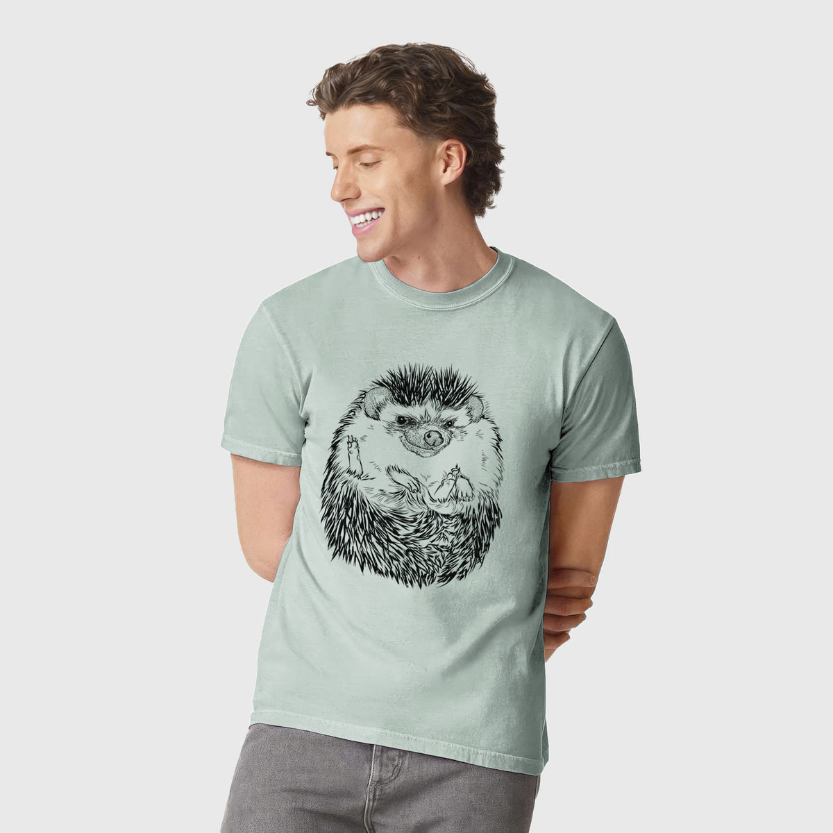 Man wearing a Comfort Colors t-shirt printed with a detailed black ink illustration of a hedgehog curled up and facing forward.