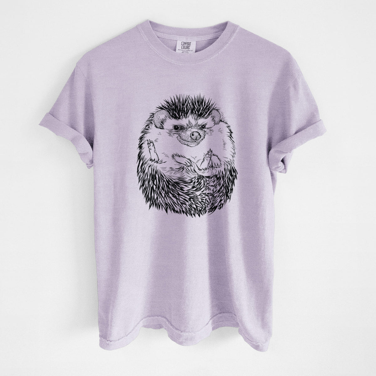 Orchid purple Comfort Colors t-shirt laid flat, printed with a detailed black ink illustration of a hedgehog curled up and facing forward.