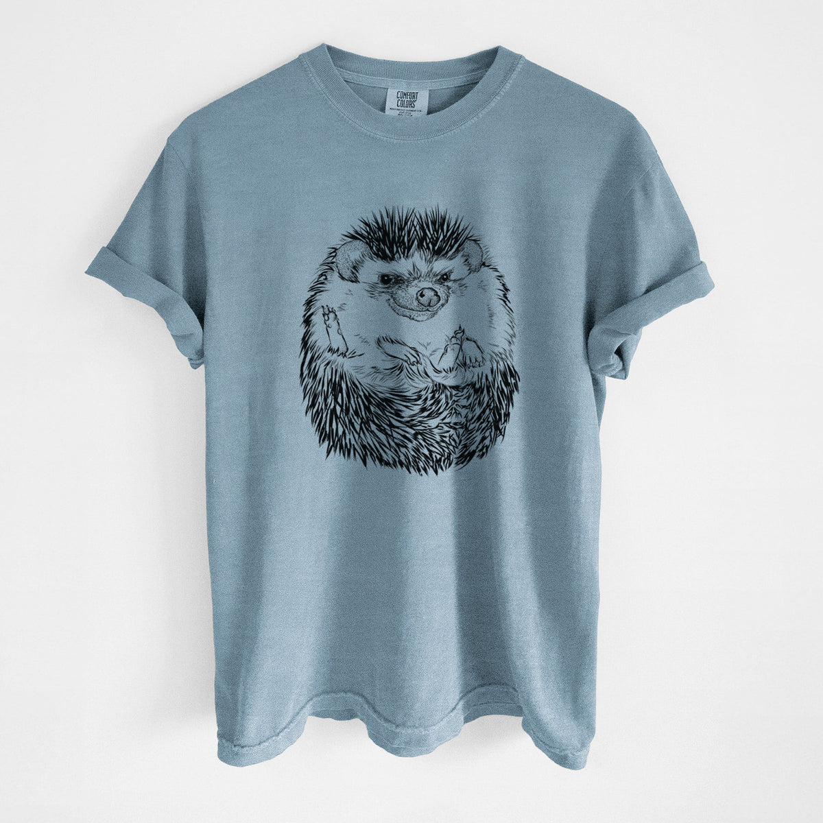 Steel blue Comfort Colors t-shirt laid flat, printed with a detailed black ink illustration of a hedgehog curled up and facing forward.