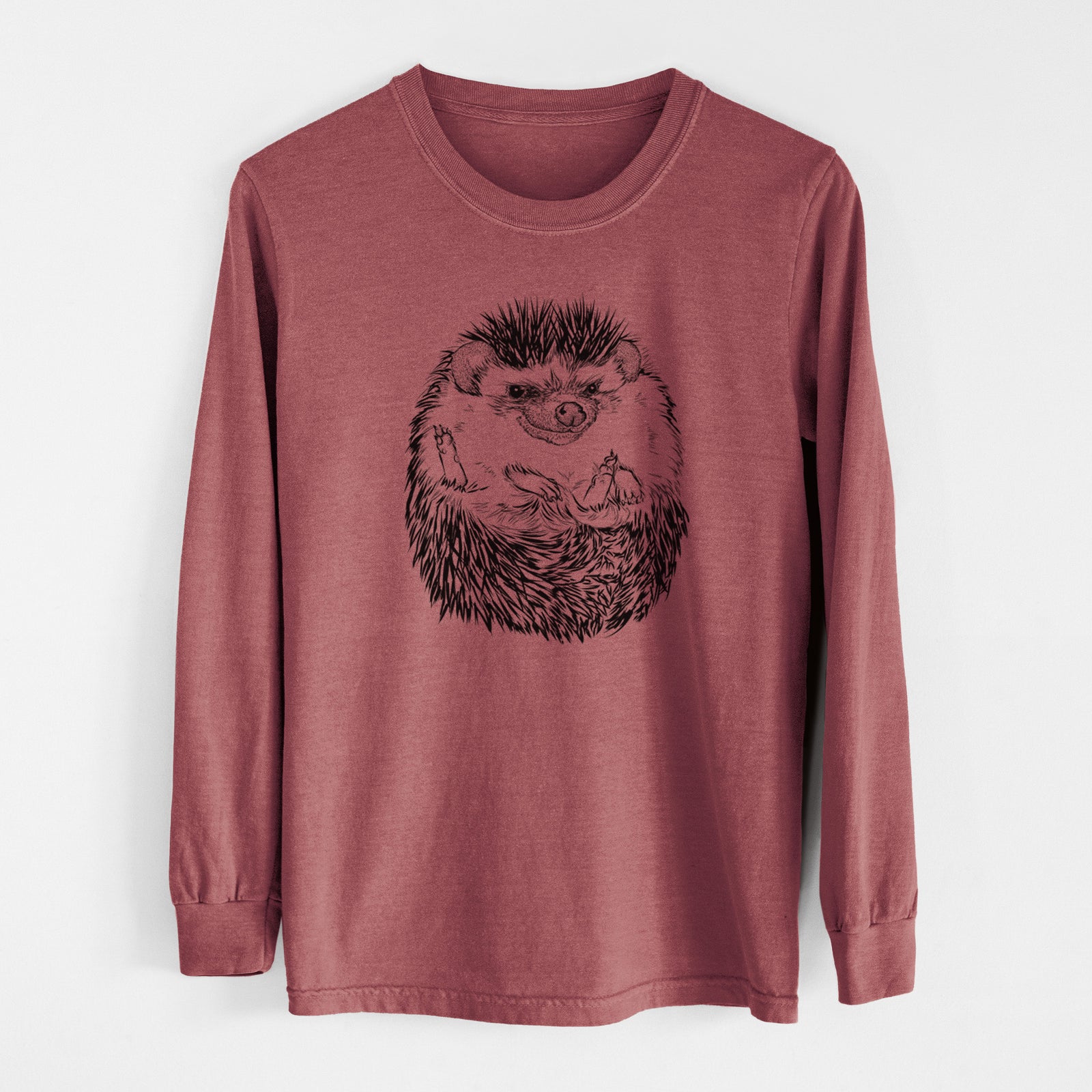Ivory Comfort Colors long sleeve shirt laid flat, printed with a detailed black ink illustration of a hedgehog curled up and facing forward.