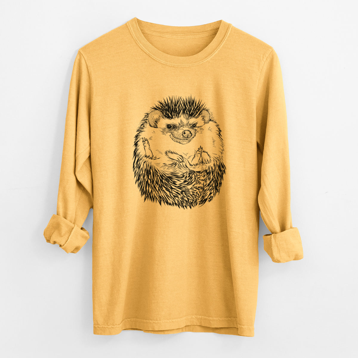 Golden wheat yellow Comfort Colors long sleeve shirt laid flat with the cuffs rolled, printed with a detailed black ink illustration of a hedgehog curled up and facing forward.