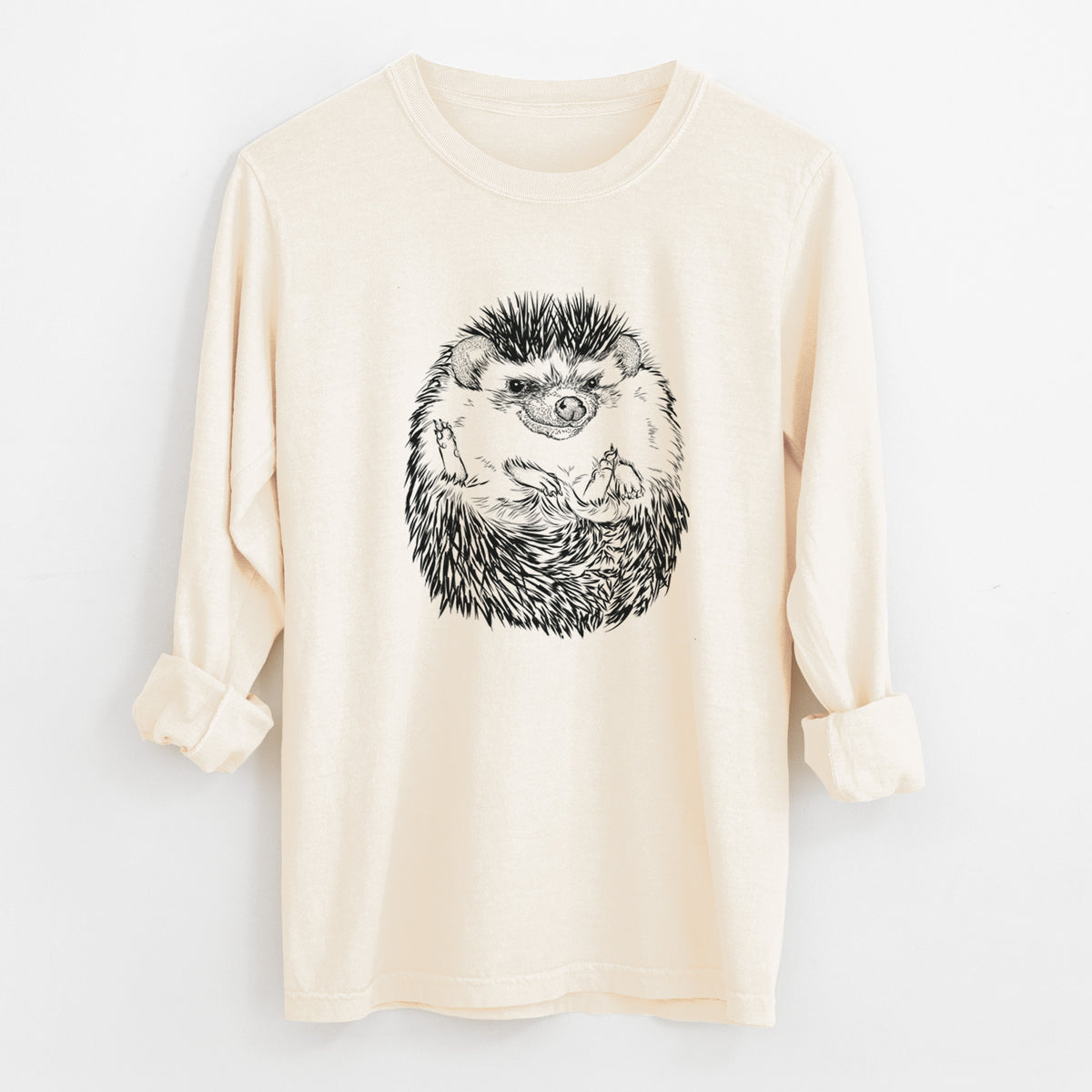 Ivory Comfort Colors long sleeve shirt laid flat with the cuffs rolled, printed with a detailed black ink illustration of a hedgehog curled up and facing forward.
