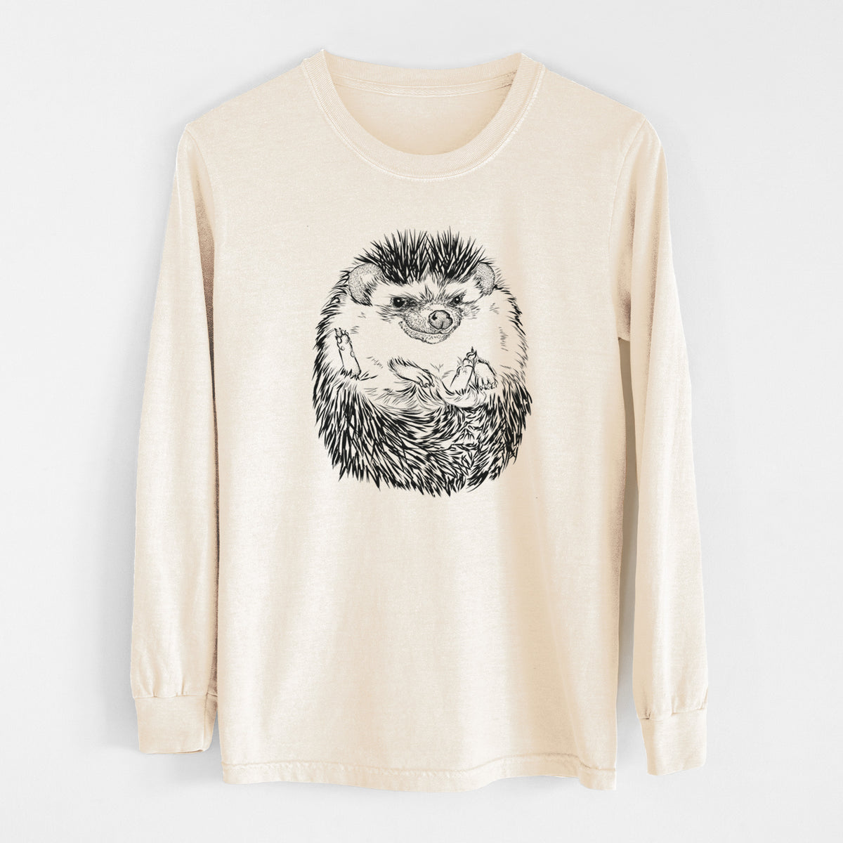Ivory Comfort Colors long sleeve shirt laid flat, printed with a detailed black ink illustration of a hedgehog curled up and facing forward.