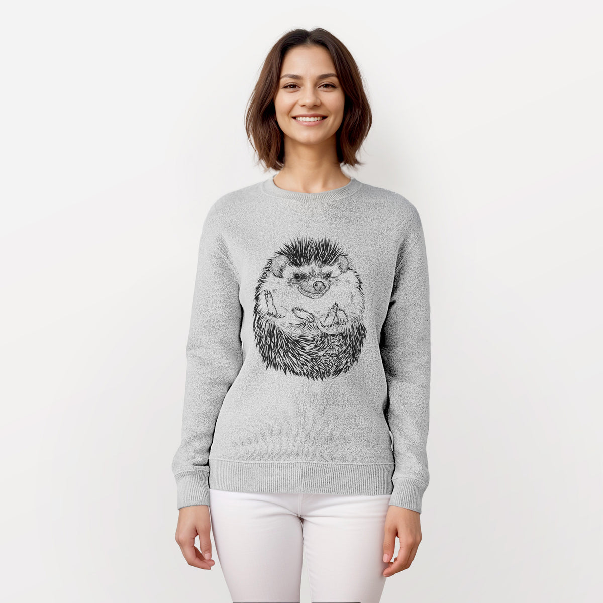 Woman wearing a knit sweatshirt printed with a detailed black ink illustration of a hedgehog curled up and facing forward.