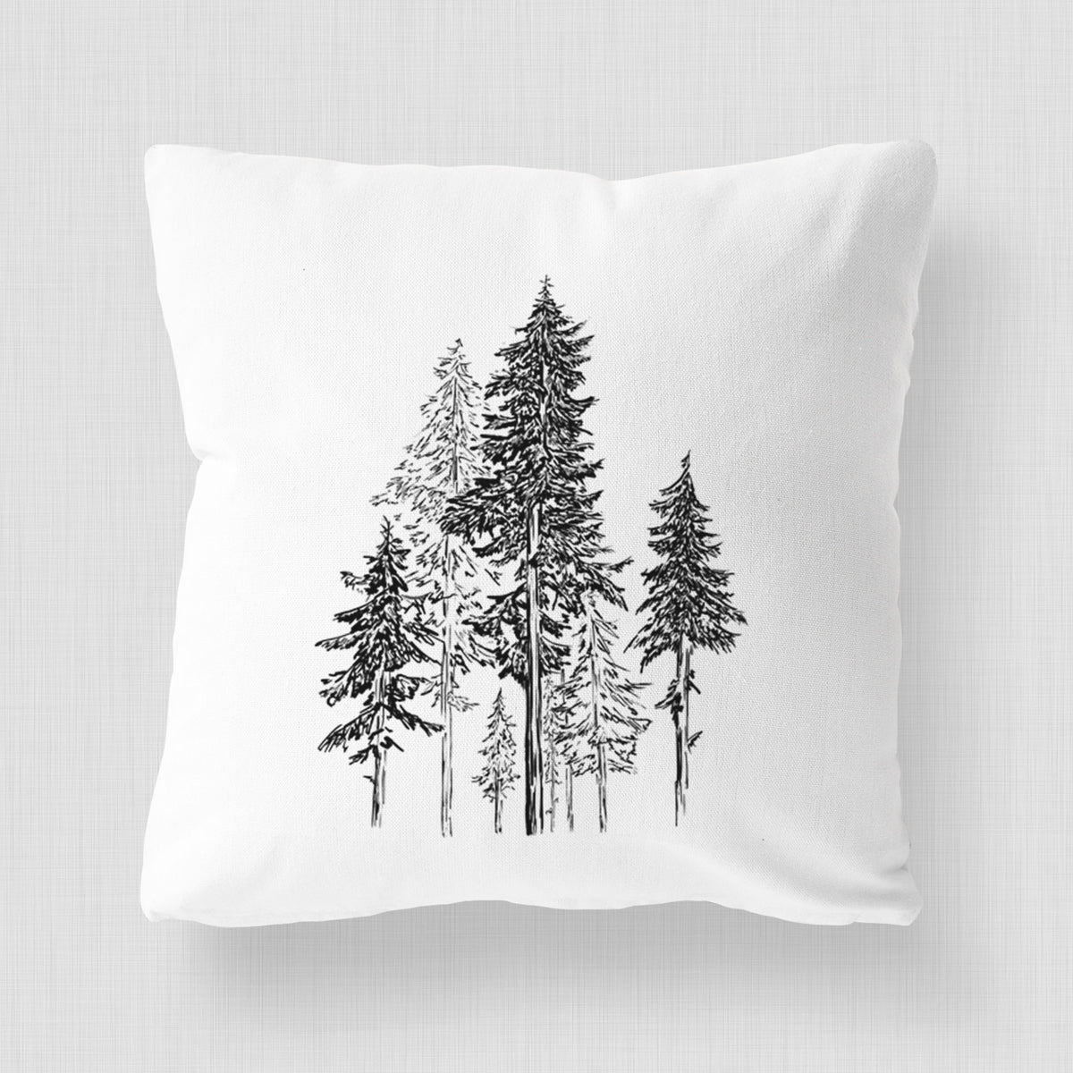 White pillow cover printed with a black ink illustration of a forest of tall hemlock trees.