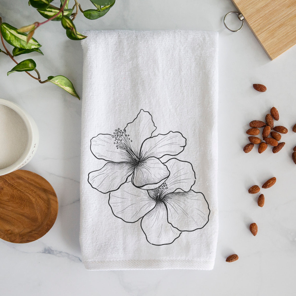 White hand towel printed with a black ink line drawing of three hibiscus flowers.