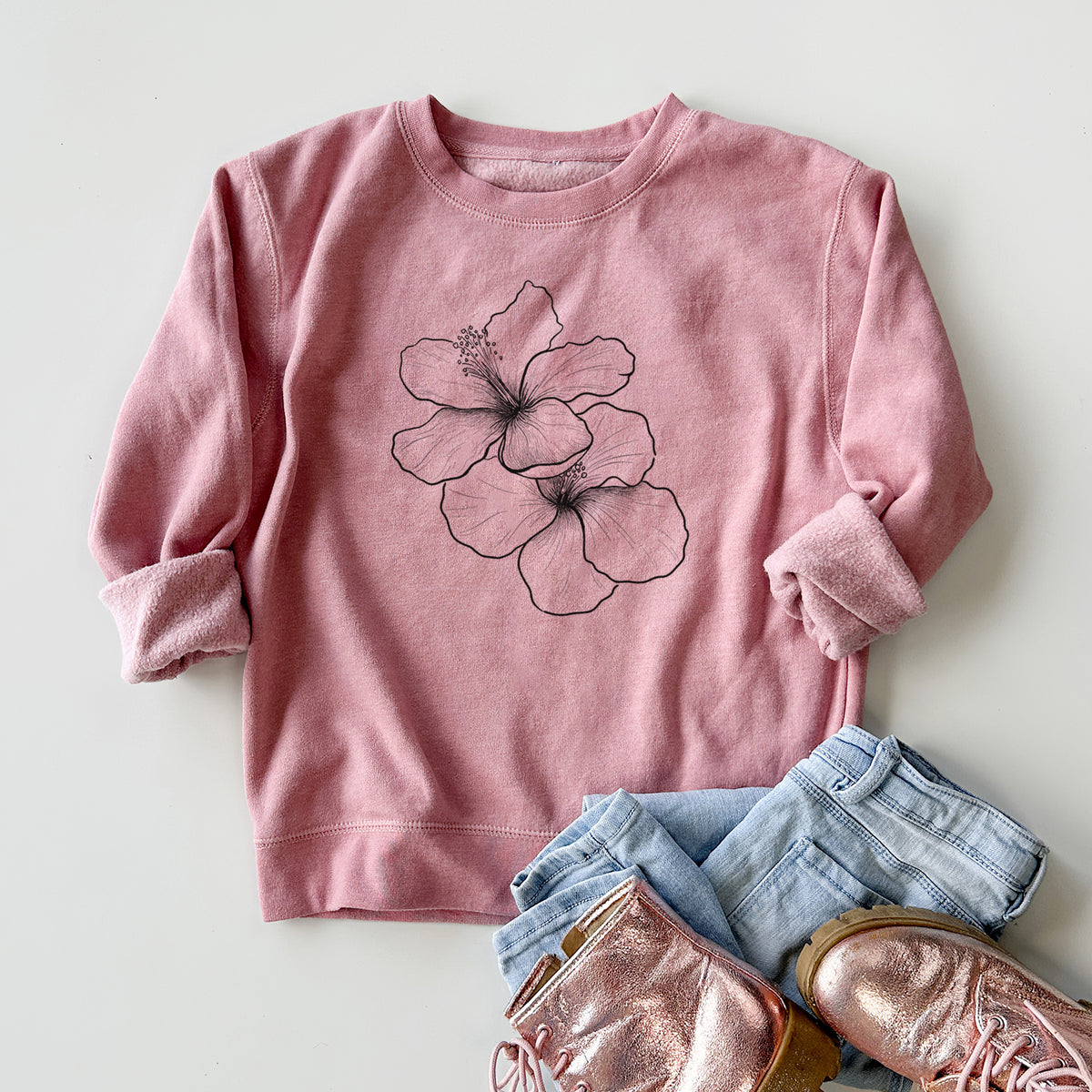 Youth crewneck sweatshirt printed with a black ink line drawing of three hibiscus flowers, styled flat with jeans and boots.