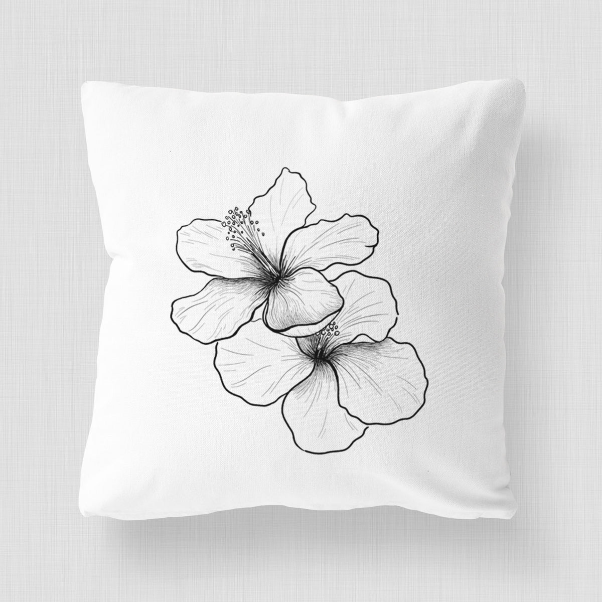 White pillow cover printed with a black ink line drawing of three hibiscus flowers.
