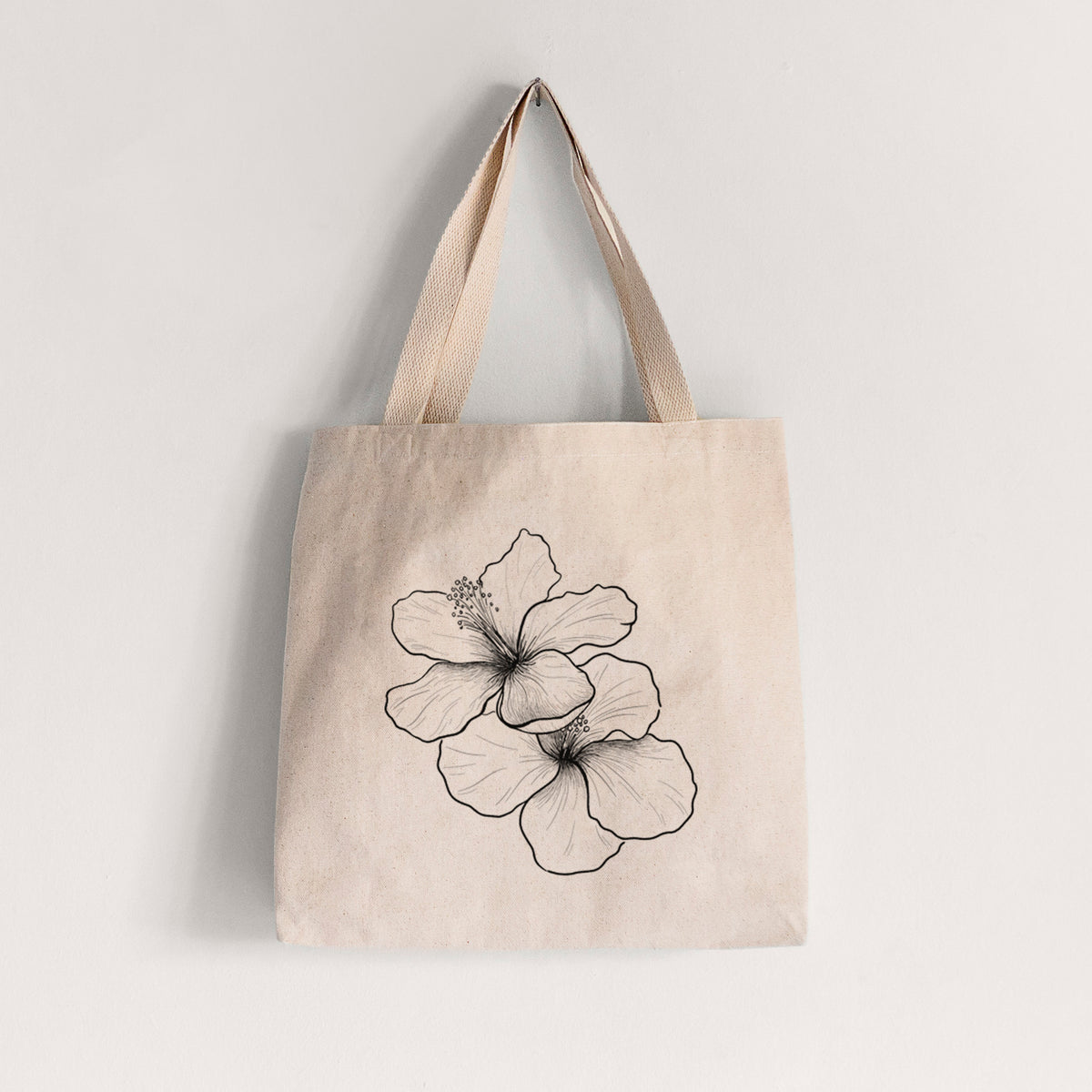 Natural canvas tote bag printed with a black ink line drawing of three hibiscus flowers.