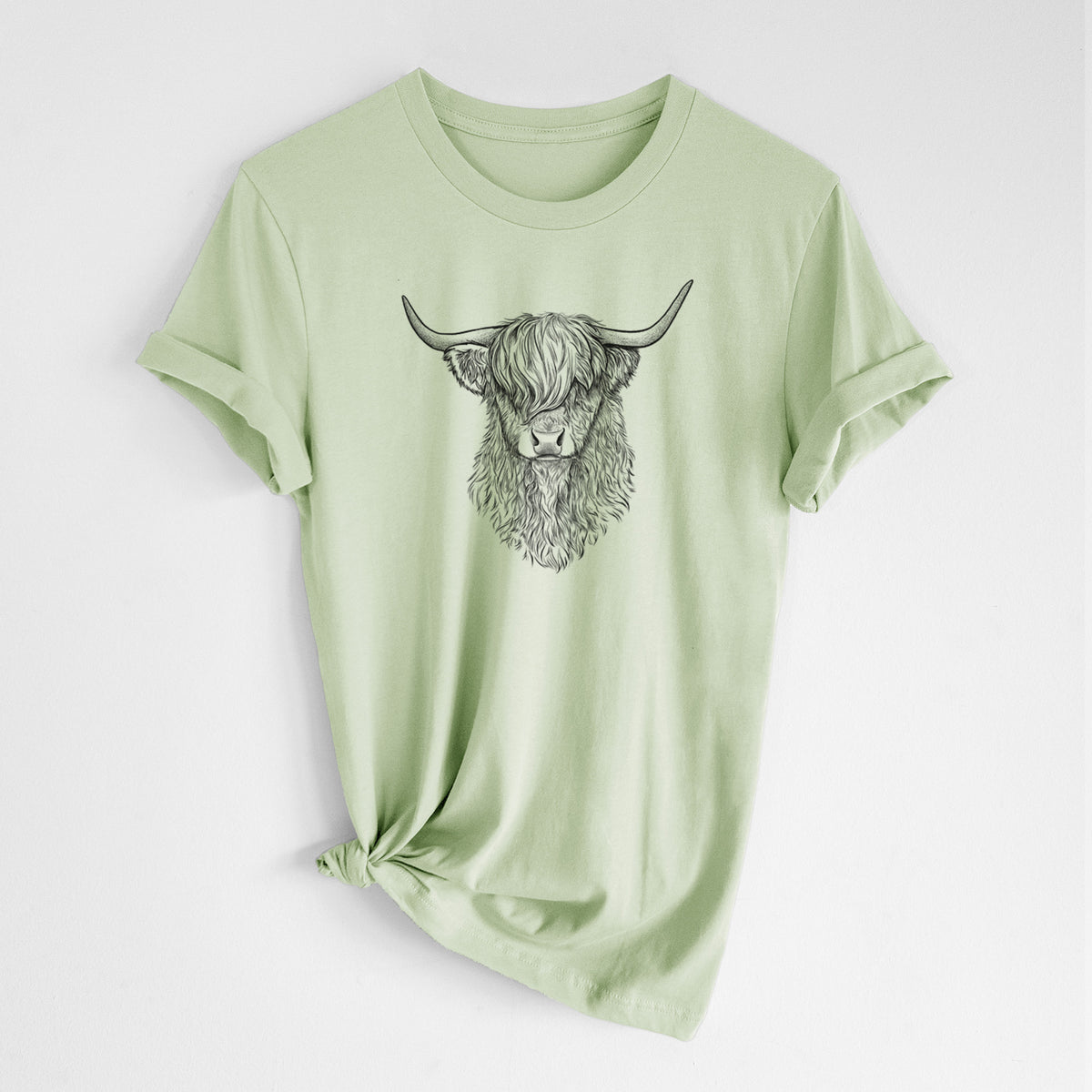 Spring green lightweight cotton t-shirt laid flat with the sleeves rolled, printed with a detailed black ink portrait of a shaggy highland cow with long curved horns.