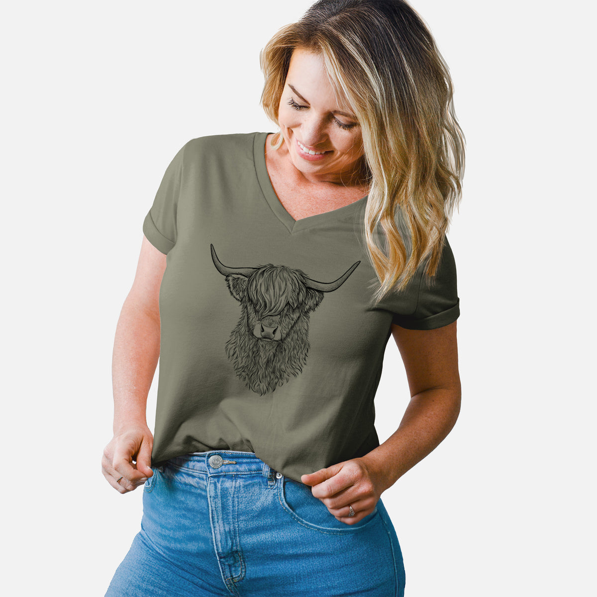 Woman wearing a military green women's relaxed fit cotton V-neck t-shirt printed with a detailed black ink portrait of a shaggy highland cow with long curved horns.