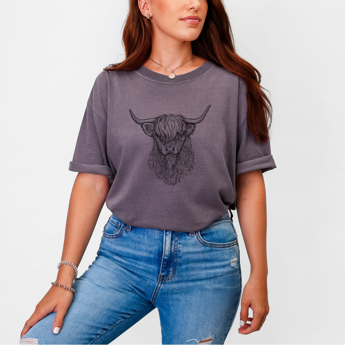 Woman wearing a Comfort Colors t-shirt printed with a detailed black ink portrait of a shaggy highland cow with long curved horns.