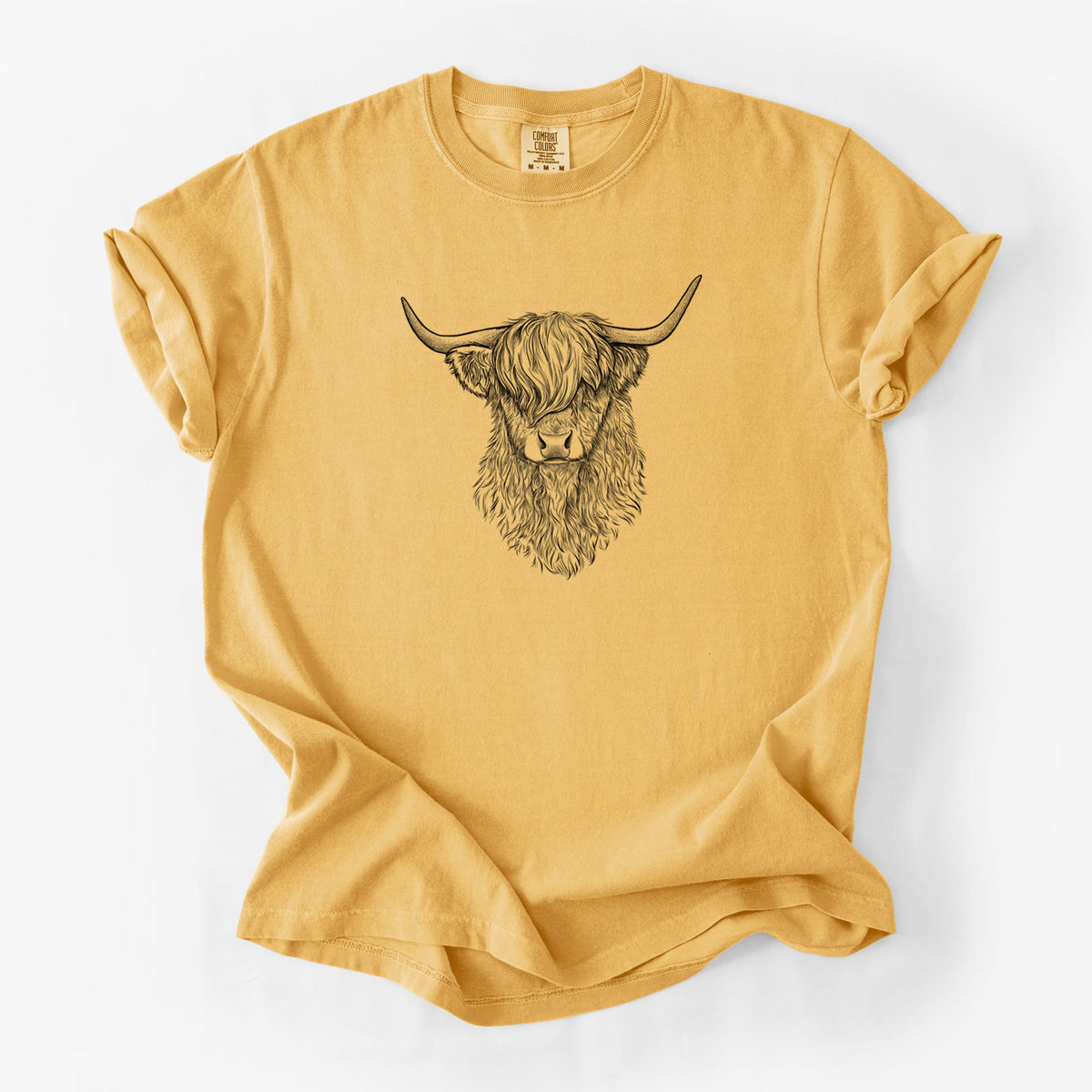 Golden wheat yellow Comfort Colors t-shirt laid flat, printed with a detailed black ink portrait of a shaggy highland cow with long curved horns.