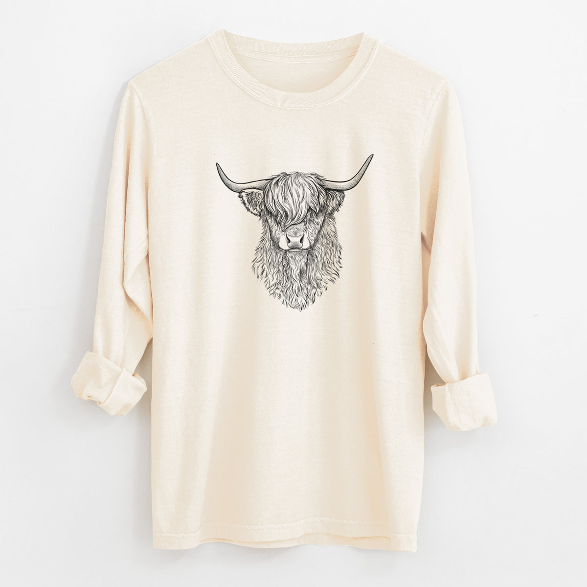 Ivory Comfort Colors long sleeve shirt laid flat with the cuffs rolled, printed with a detailed black ink portrait of a shaggy highland cow with long curved horns.