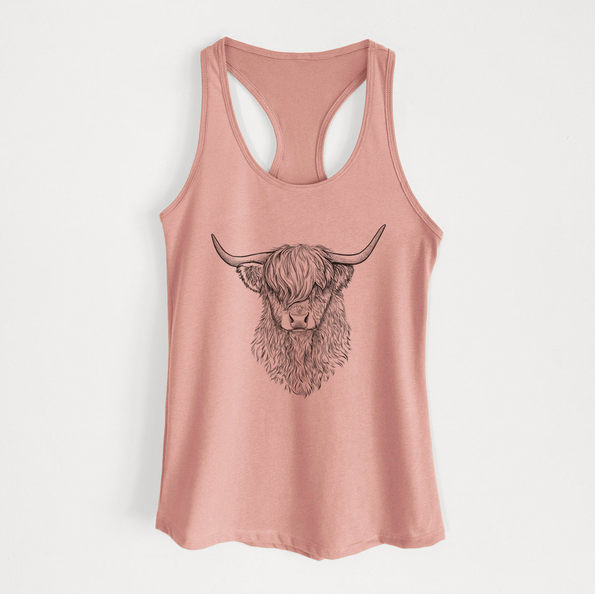 Desert pink women's racerback tank top laid flat, printed with a detailed black ink portrait of a shaggy highland cow with long curved horns.